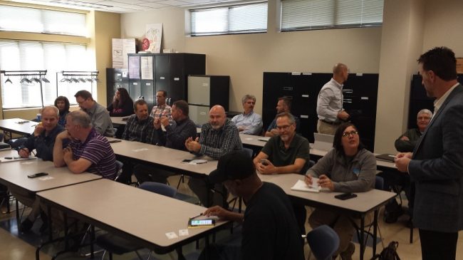Employees in conference with their pens and notepads