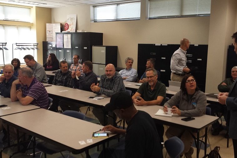 Employees in conference with their pens and notepads