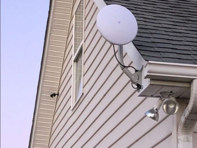 Circle dish attached to roof of house
