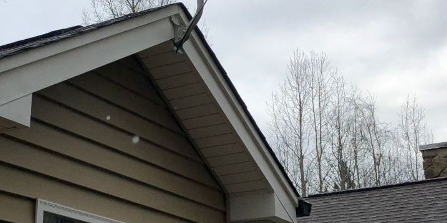 Dish attached to peak of roof of brown house